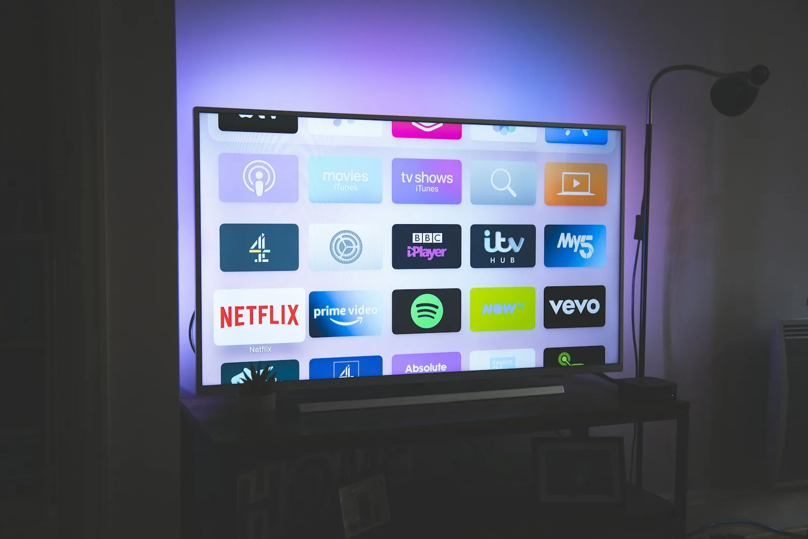Smart TV moderna na sala de estar exibindo a interface do RX Purple em 4K